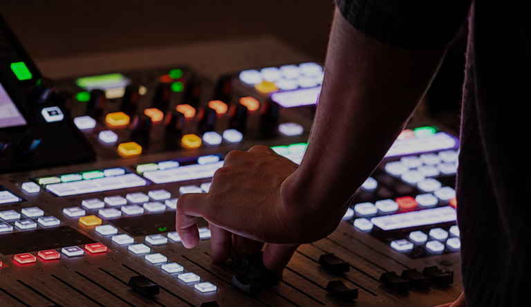 AV technician operating a professional lighting control console during a live production
