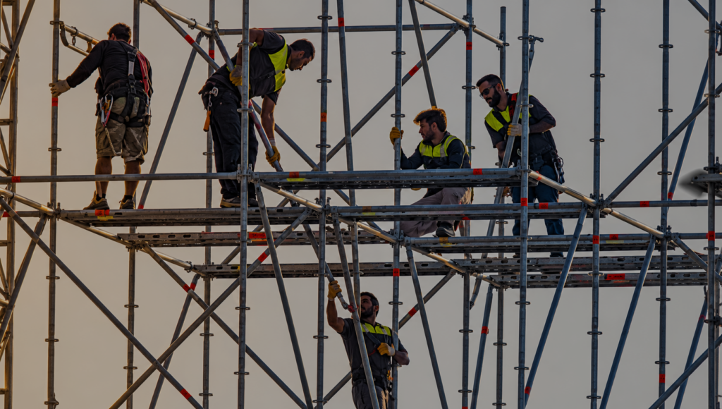 Stagehands working on elevated scaffolding during stage construction for a live event